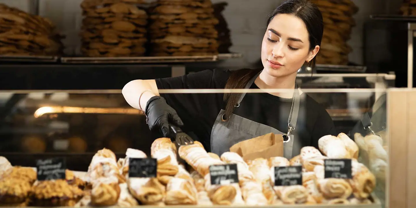 Frau verkauft in Bäckerei Backwaren