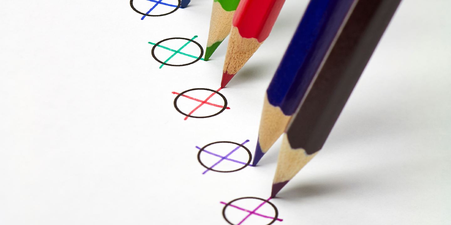 Verschiedenfarbige Stifte machen zur Wahl Kreuze auf Stimmzettel