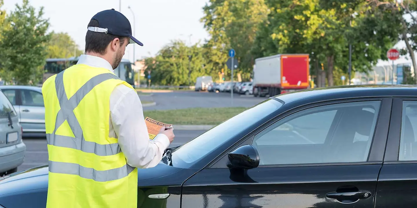 Kontrolleur stellt Knöllchen bei Falschparker aus